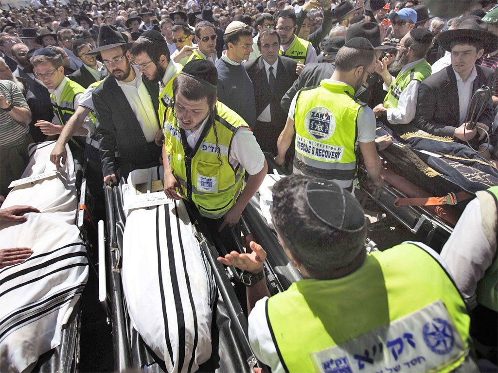 Mourners file past the coffins