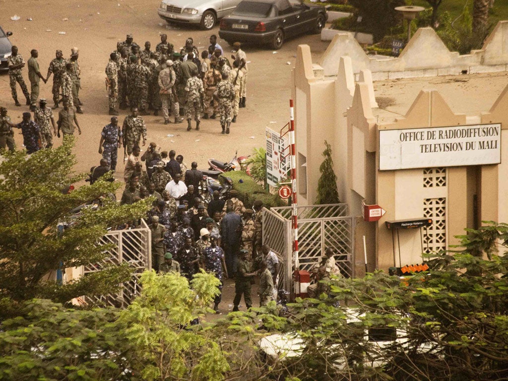 Malian soldiers and security forces gather at the offices of the state radio and television broadcaster after announcing a coup d'etat