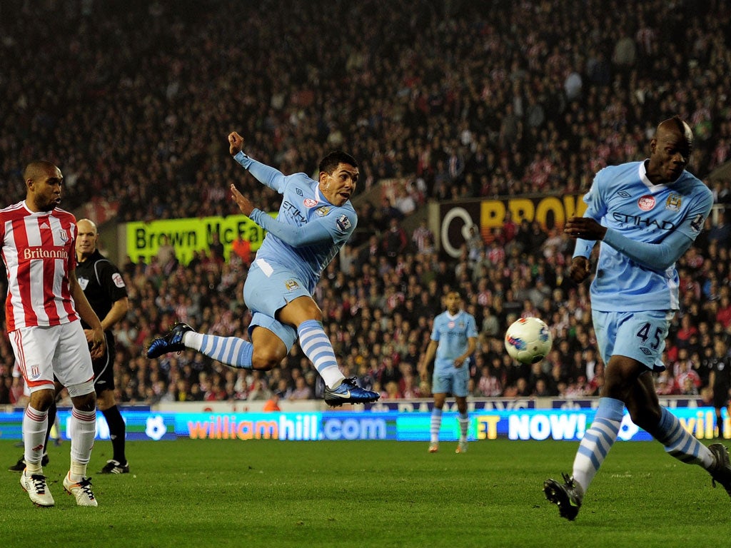 Flying Visit: Carlos Tevez blasts a shot towards goal at the Britannia Stadium yesterday