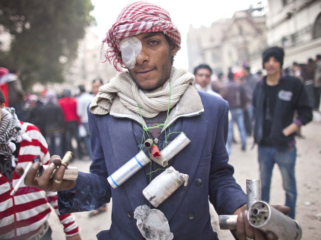 A protester shows tear gas cartridges shooten by the riot police during clashes between protesters and riot police in Cairo