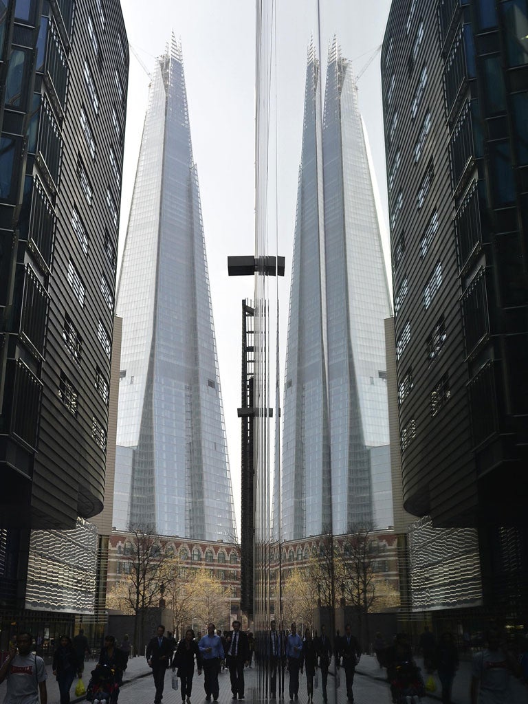 Pedestrians walk near The Shard building at London Bridge