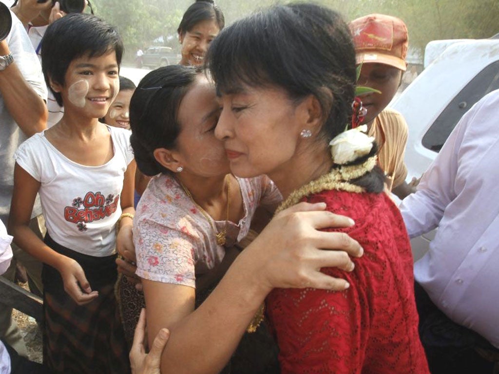 A voter embraces Aung San Suu Kyi at a polling station in Kawmhu
