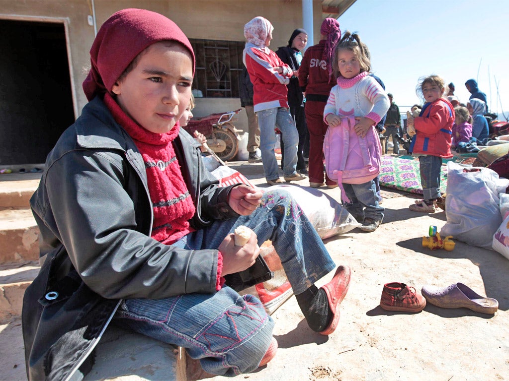 Syrian children who fled with their families from Qusair, near Homs, wait at the Lebanese border