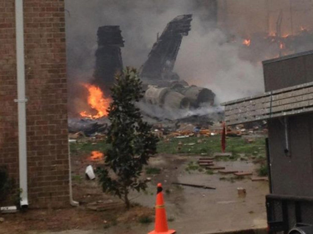 The burning fuselage of an F/A-18 Hornet lies smoldering after crashing into a residential building in Virginia Beach