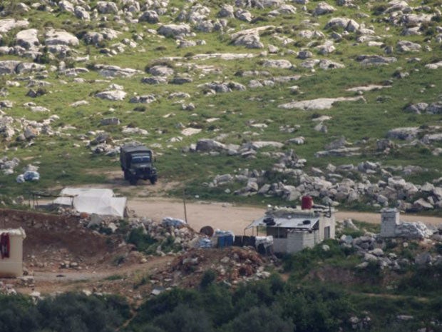 Syrian soldiers patrol a field at the village of Al Msherfeh