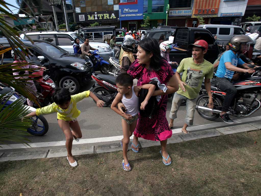 Acehnese people run shortly after a powerful earthquake hit the western coast of Sumatra in Banda Aceh