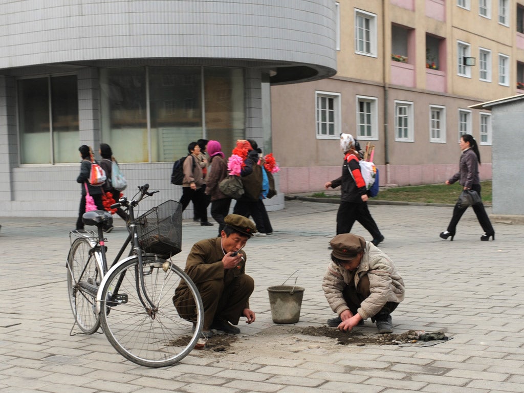 Workers repair a road by hand