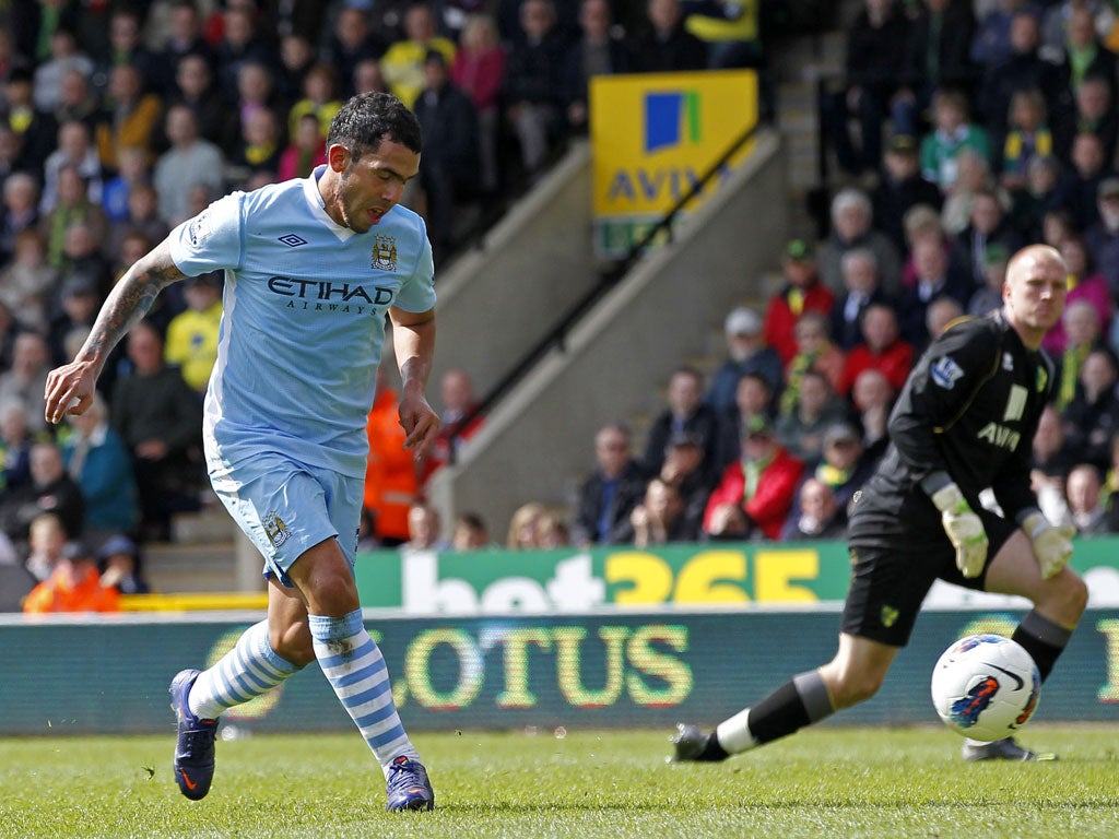 Carlos Tevez rounds Norwich City's goalkeeper John Ruddy to complete his hat-trick