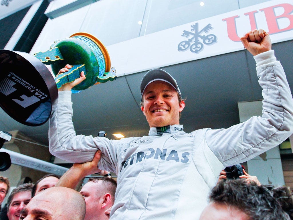 Triumphant Nico Rosberg raises his first grand prix winner’s trophy