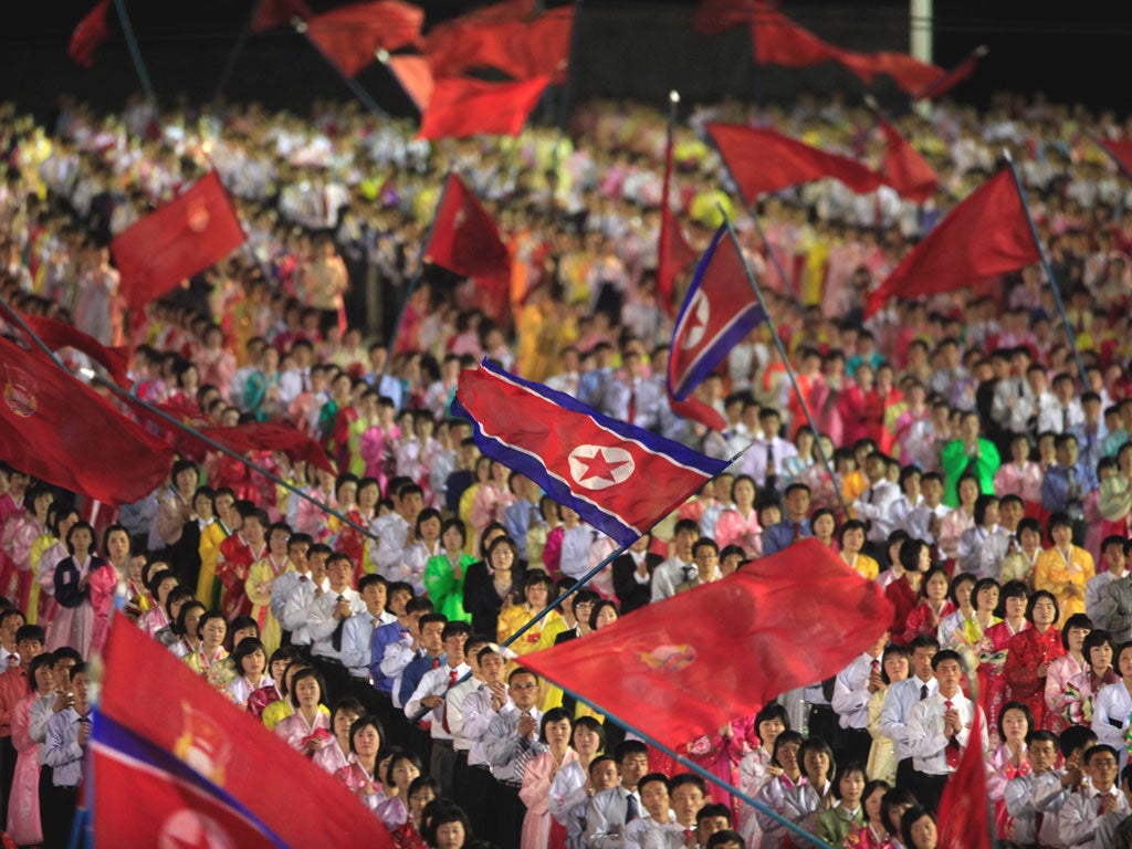 North Korean students wave their national flags at Kim Il Sung Square to commemorate the late President Kim Il Sung's 100th birthday in Pyongyang