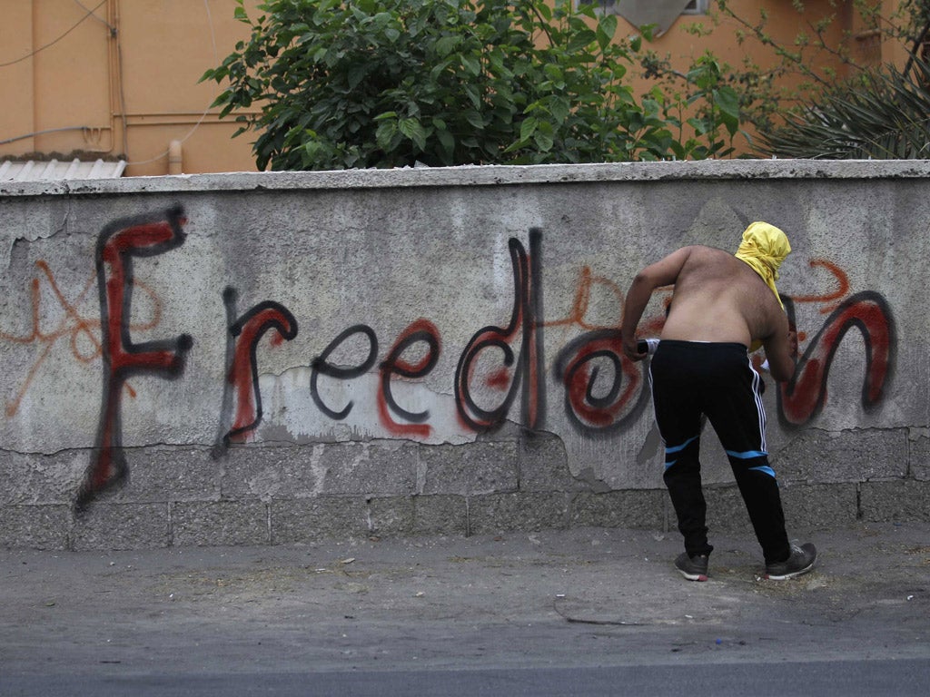 A demonstrator sprays graffiti in Diraz village, west of Manama yesterday