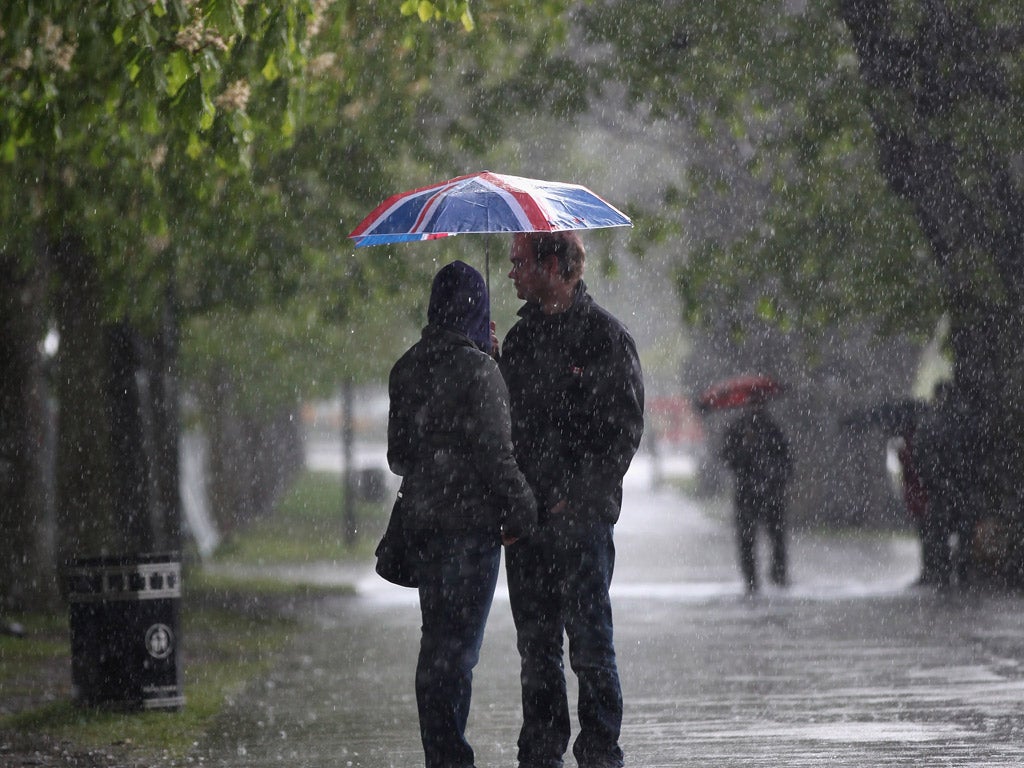 People shelter from the rain in Greenwich Park this week