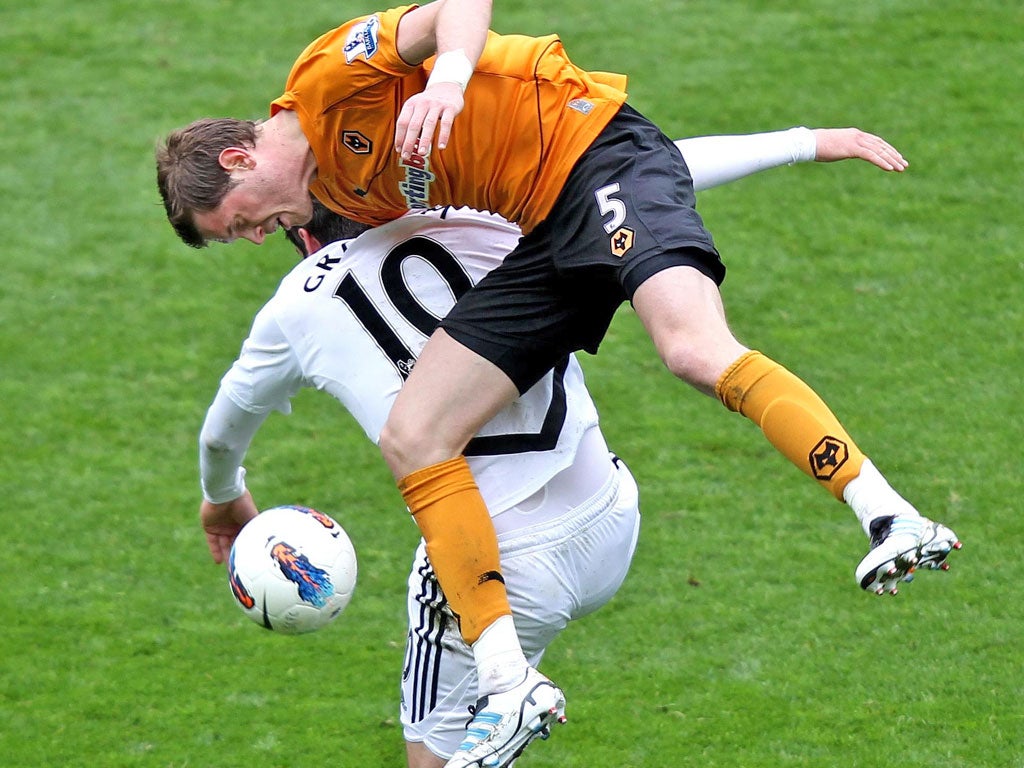 Ugly Swan: Danny Graham is all arms and legs as he loses a header to Wolves’ Richard Stearman during yesterday’s 4-4 draw at the Liberty Stadium