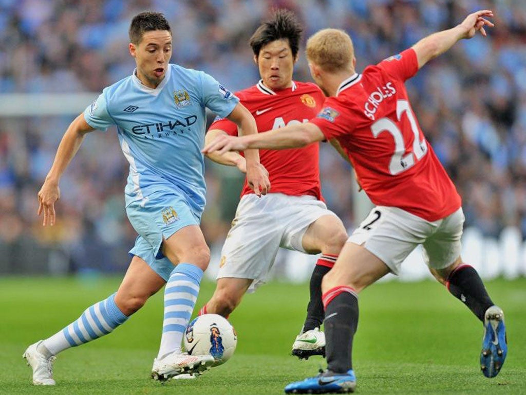 Samir Nasri darts between United’s Paul Scholes and Park Ji-sung