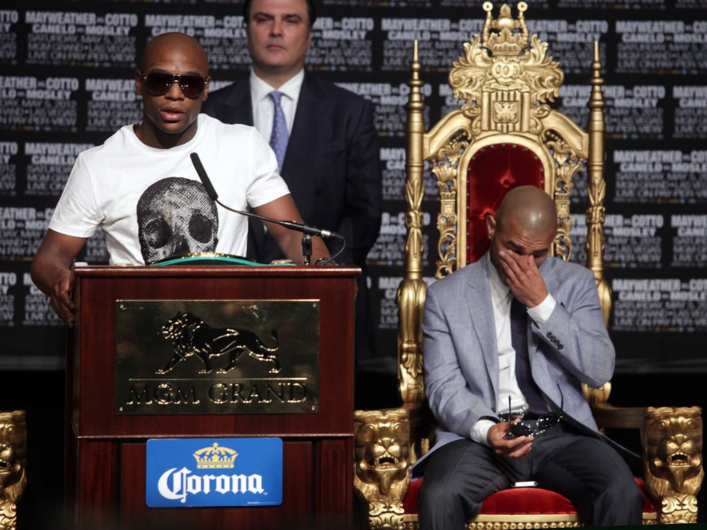 Miguel Cotto seems unimpressed as Floyd Mayweather takes to the stage