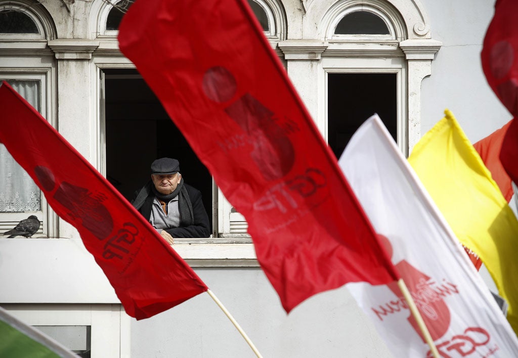 A man watches protests against austerity in Lisbon, Portugal