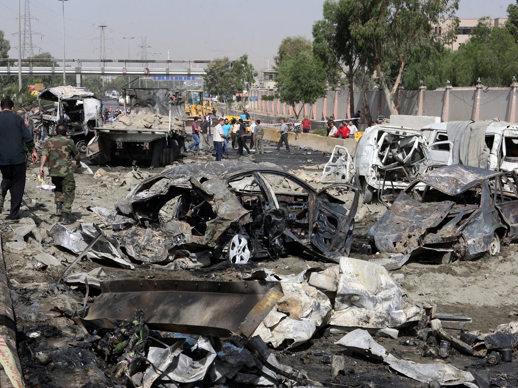 Syrians inspect damages at the site of twin blasts in Damascus