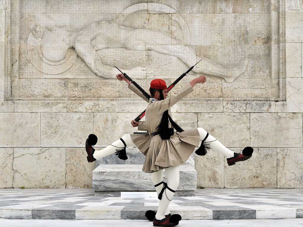 Greek Presidential guards perform in front of the tomb of the Unknown soldier in central Athens