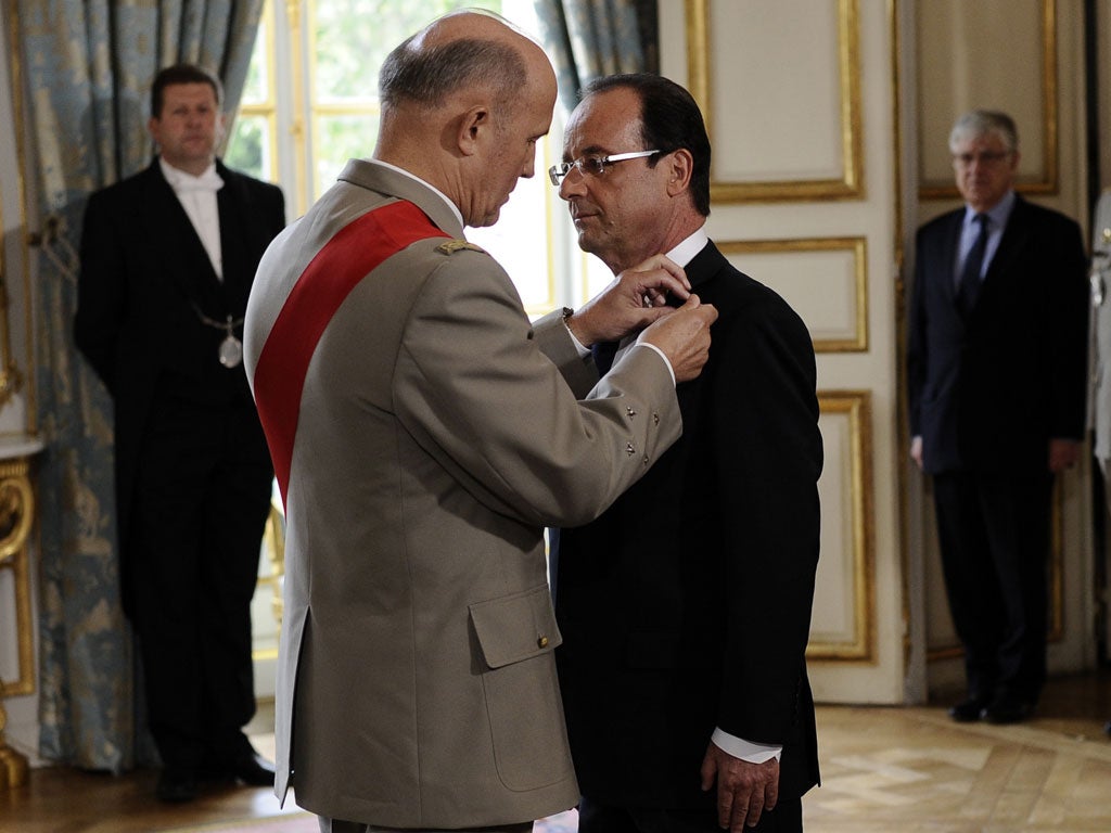 Francois Hollande is awarded 'Grand Maitre' in the Order of the Legion of Honor, from chancellor of France's National Order of the Legion of Honor, General Jean-Louis Georgelin