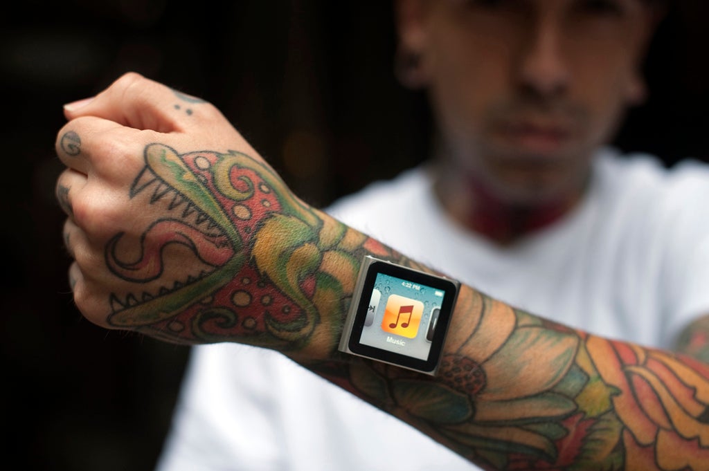Tattoo artist Dave Hurban displays an iPod Nano which he has attached to his wrists through magnetic piercings in his wrist in New York.
