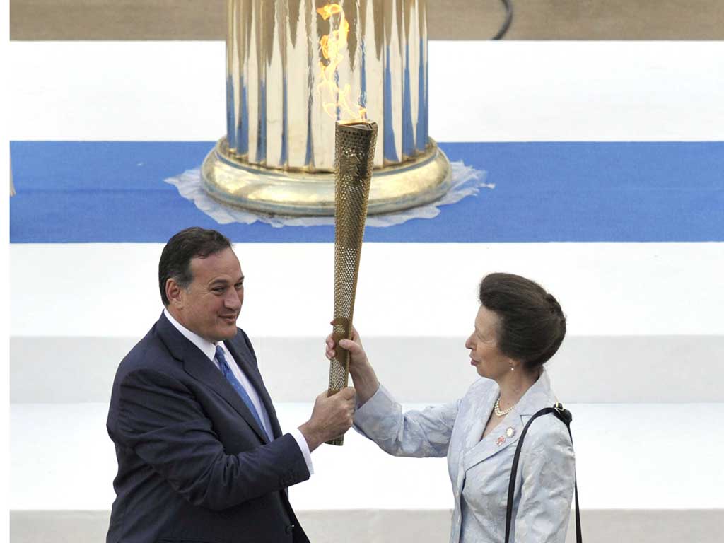 The Princess Royal is handed the Olympic torch