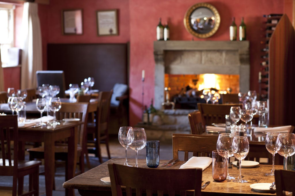 The White Swan Inn's dining room is an object lesson in refurb, with maroon walls, stone-flagged floor and room dividers in the form of folding screens