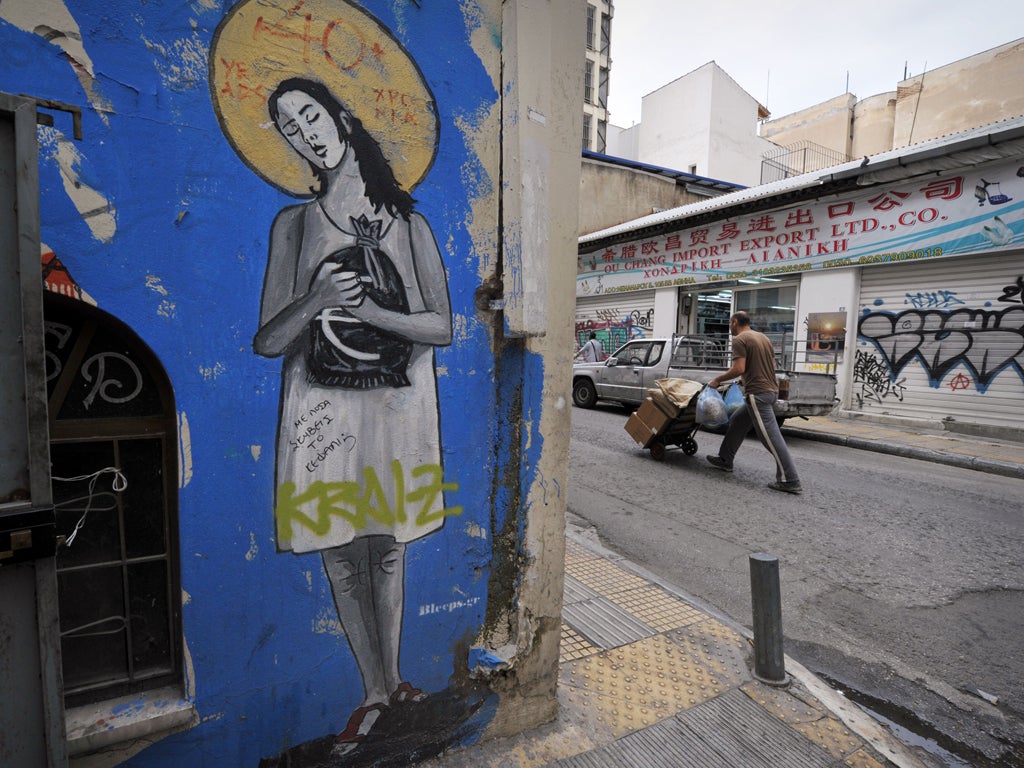 A man pushes a cart through central Athens