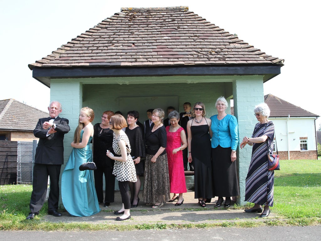 Residents of Kingston Bagpuize in Oxfordshire wait for buses to take them to the premiere