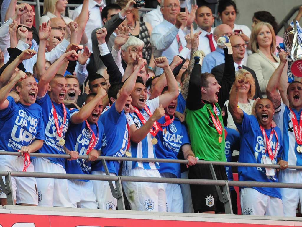 We are going up: Huddersfield's triumphant players collect the play-off trophy and medals after their victory