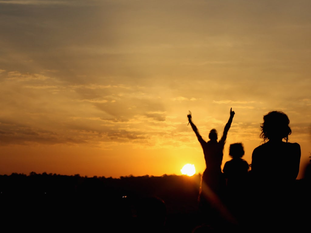Glastonbury: Festival goers gather to see the sunrise from the Stone Circle area at the Glastonbury Festival