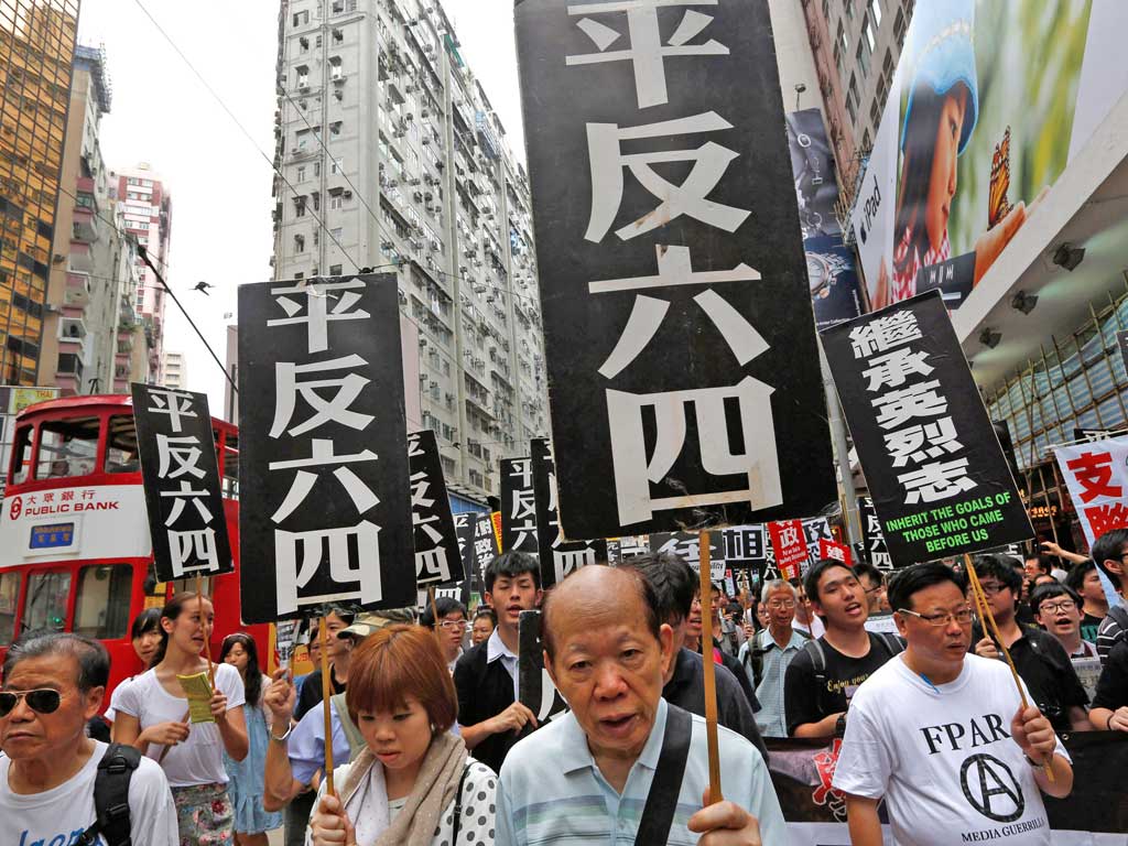 Protesters show placards that read ‘Exonerate the June 4’ during a rally in Hong Kong ahead of the 23rd anniversary of the military crackdown on the pro-democracy movement in Beijing