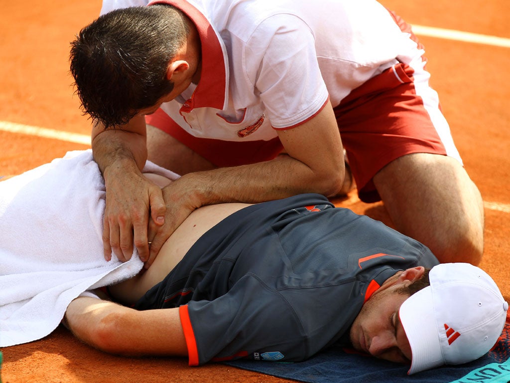 Murray receives assistance for a back problem during his match against Jarkko Nieminen