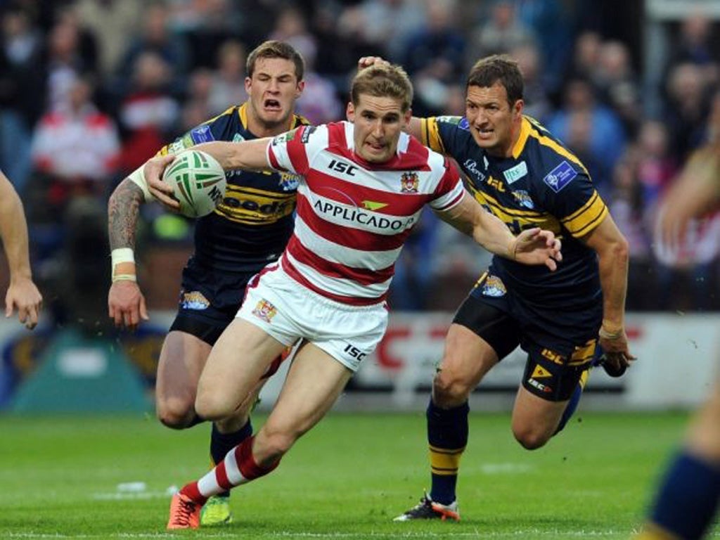 Sam Tomkins beats the challenge of Leeds' Zak Hardaker
(left) and Danny McGuire at Headingley last night