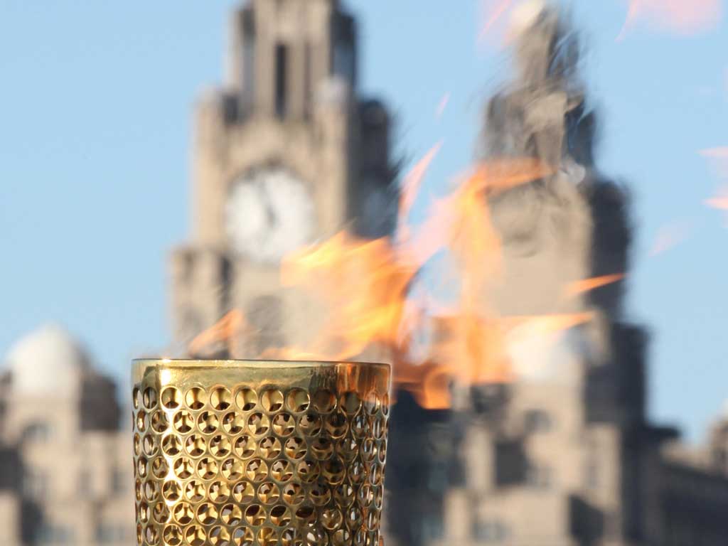 Flaming June: The Olympic torch pauses in Liverpool during its long journey around the United Kingdom before the Games begin in London next month