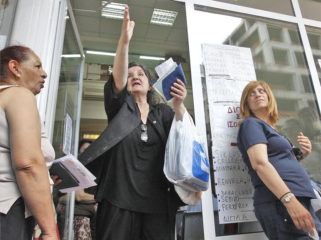 People wait for prescriptions at a state health fund office in Athens