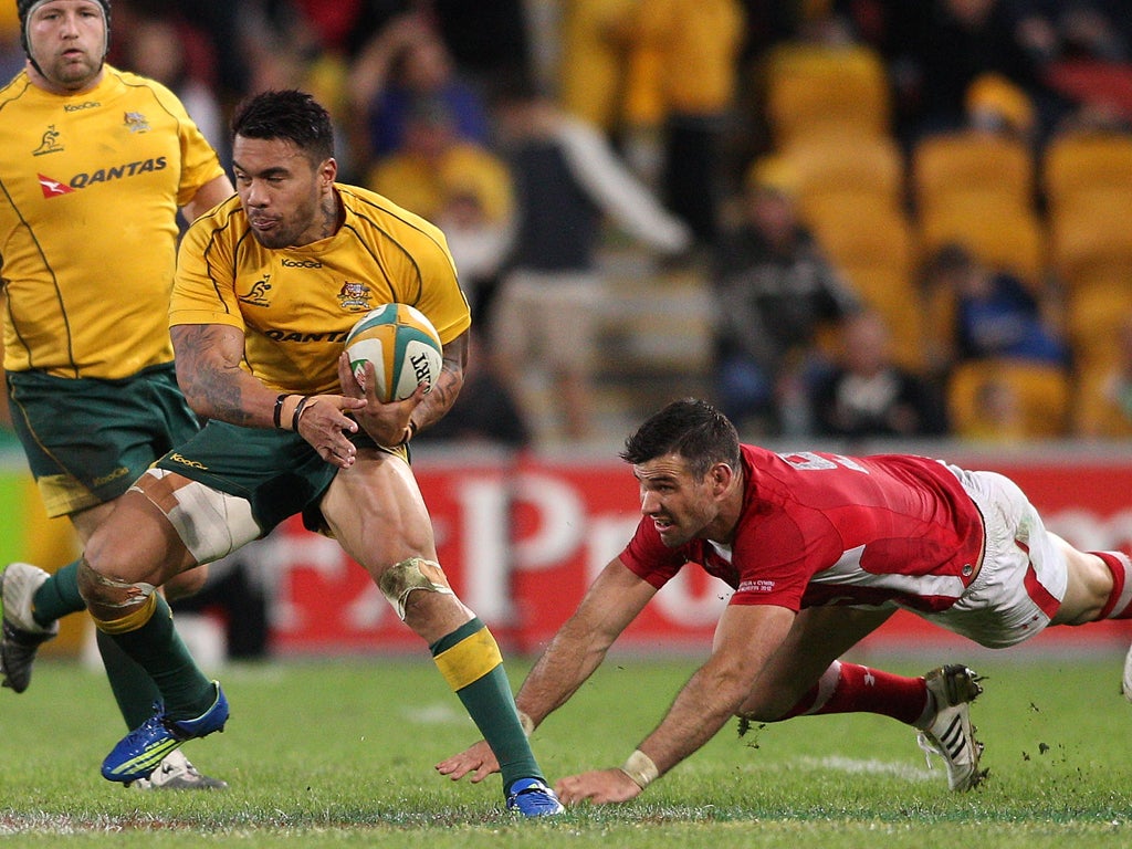 Wallabies Digby Ioane scramples passed Wales scrum-half Mike Phillips