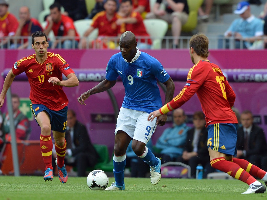 Mario Balotelli of Italy takes on Spain's Sergio Ramos and Alvaro Arbeloa