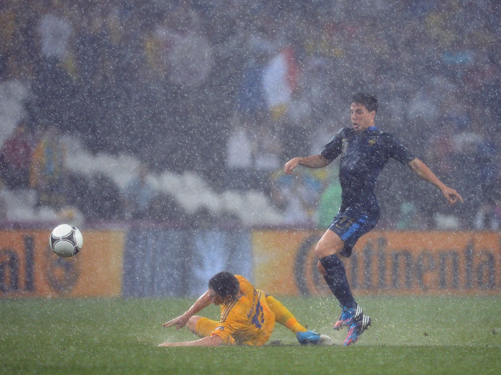 Nasri of France plays through the rain