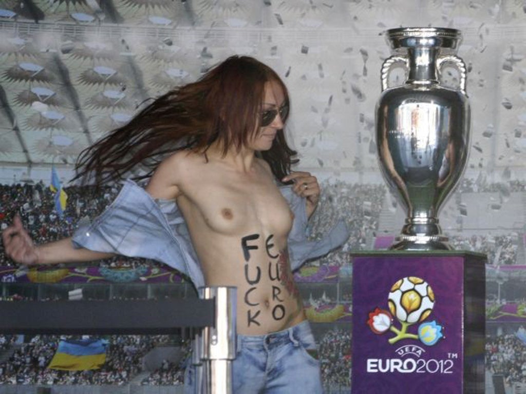 A Femen activist protests near the Euro 2012 trophy last month