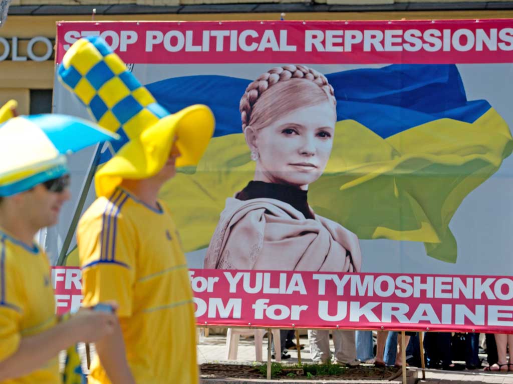 Swedish football fans in Kiev pass a poster calling for the release of Yulia Tymoshenko