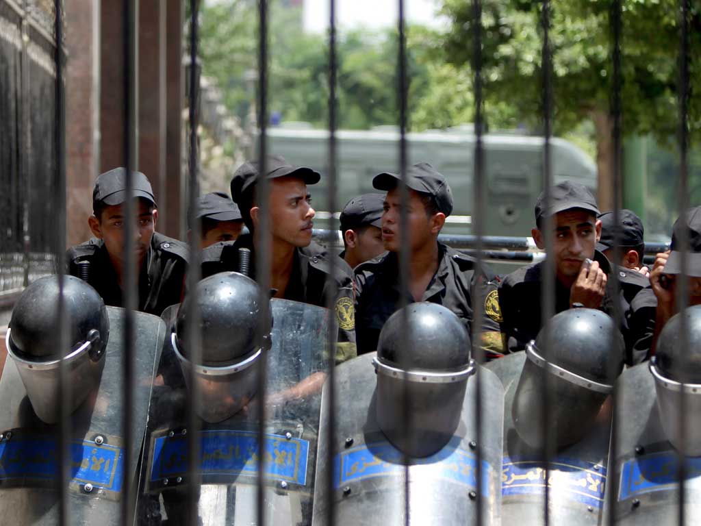 Egyptian riot police stand outside the parliament as protesters gather in Cairo