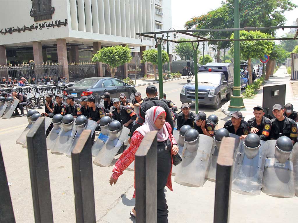 A woman passes security forces blocking access to parliament in Cairo