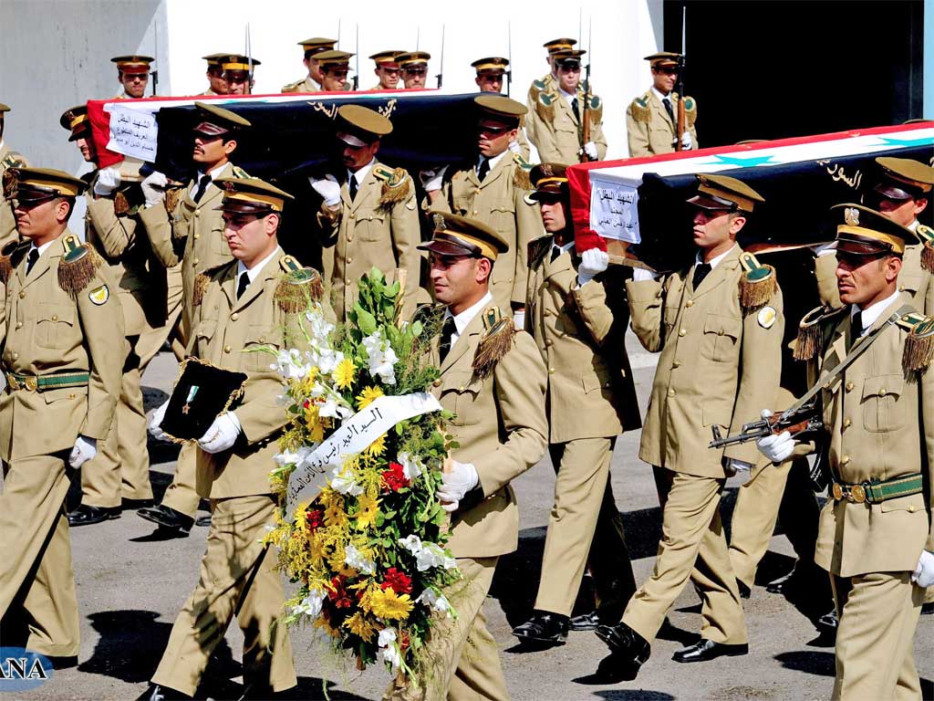 A photograph released by the official Syrian Arab News Agency shows policemen carrying coffins of their comrades in Damascus