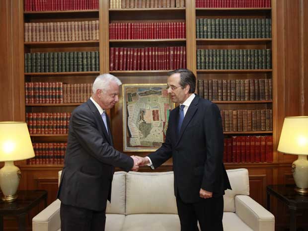 Newly appointed Greek prime minister Antonis Samaras (right) shakes hands with outgoing caretaker prime minister Panagiotis Pikrammenos