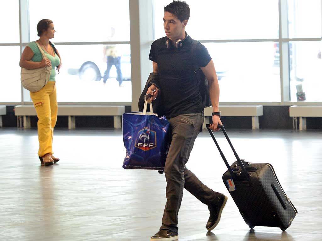 Bags packed: Samir Nasri on his way back to Paris yesterday