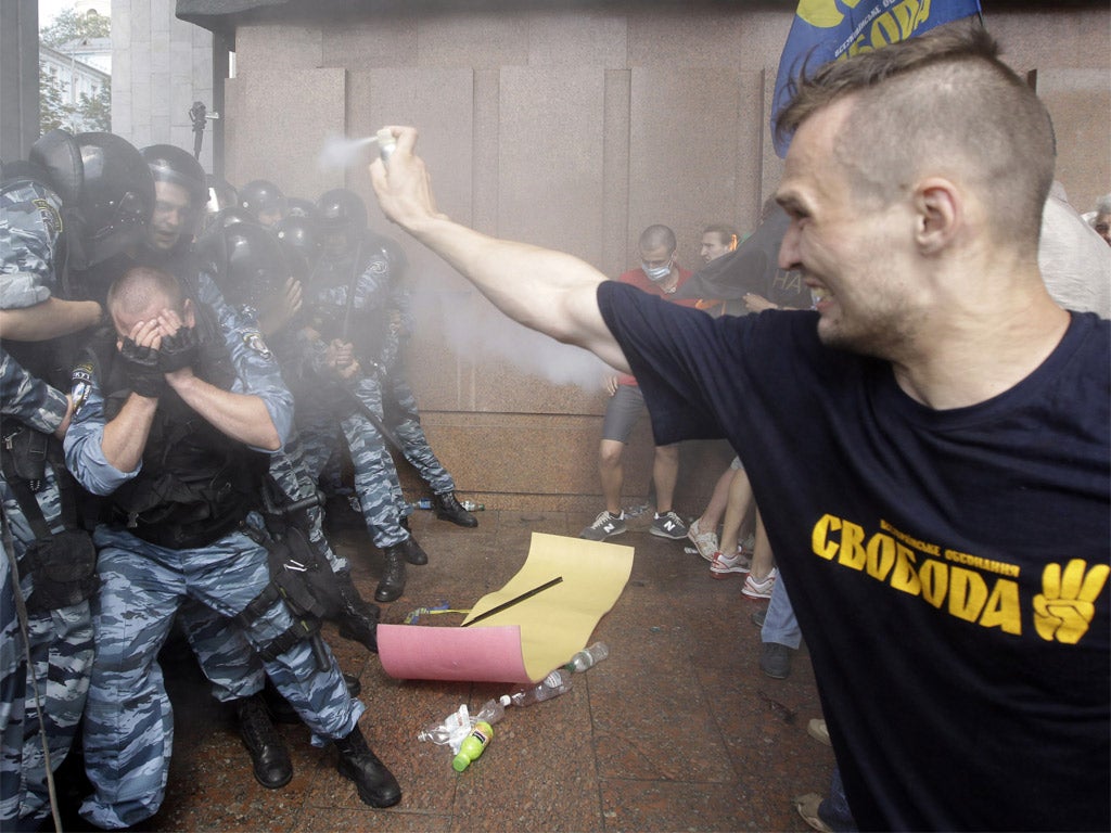 Pro-Ukrainian protesters spray tear gas at riot police near the parliament building in Kiev yesterday