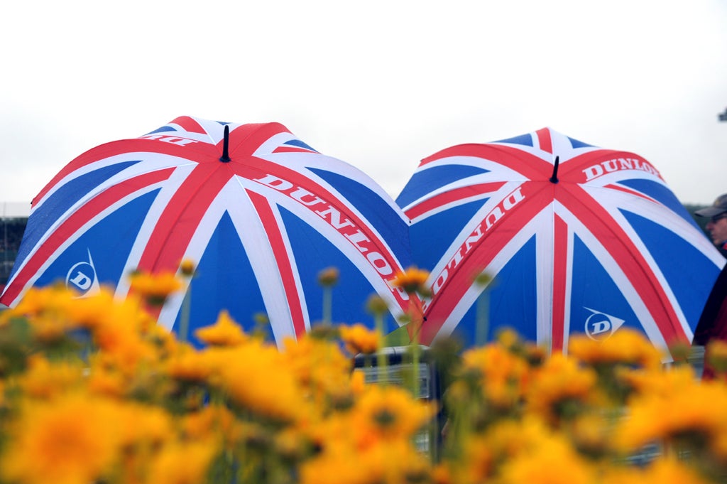 Spectators stand in the rain during the first practice session at the Silverstone circuit on July 6, 2012 ahead of the British Formula One Grand Prix.