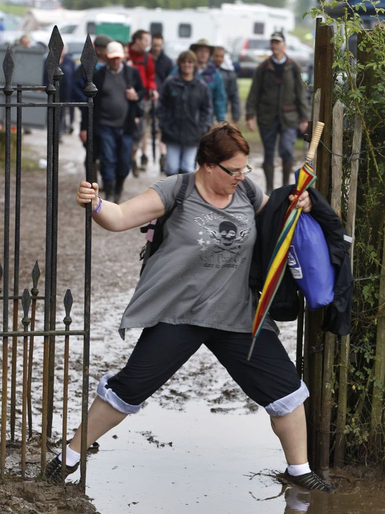 A Formula One fan negotiates the mud as she makes her way from a campsite to the main circuit at Silvestone yesterday