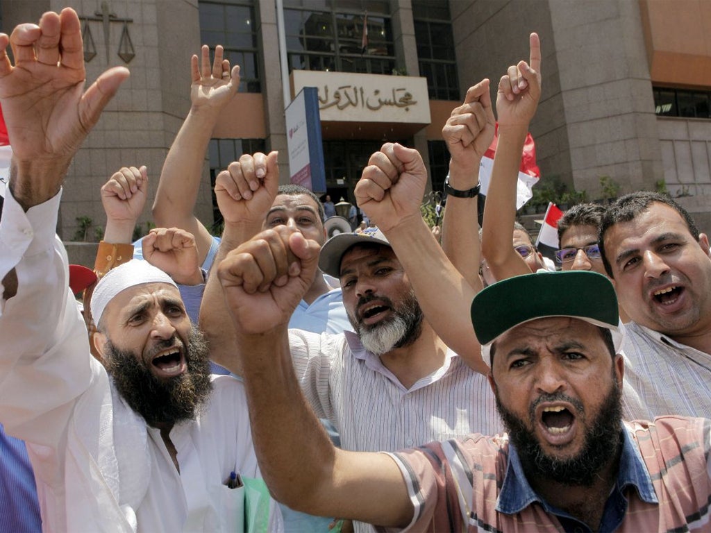 Supporters of president Mohammed Morsi chant slogans during a demonstration in front of Egypt's state council in Cairo yesterday