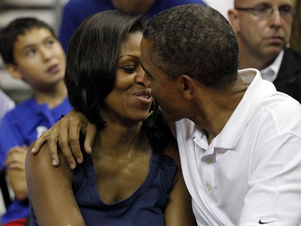 Barack Obama leans in to kiss first lady Michelle at the game